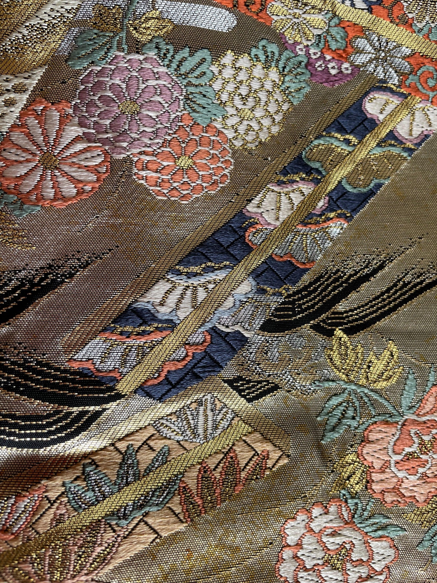 Close-up of vintage Japanese obi fabric with floral embroidery and gold threads