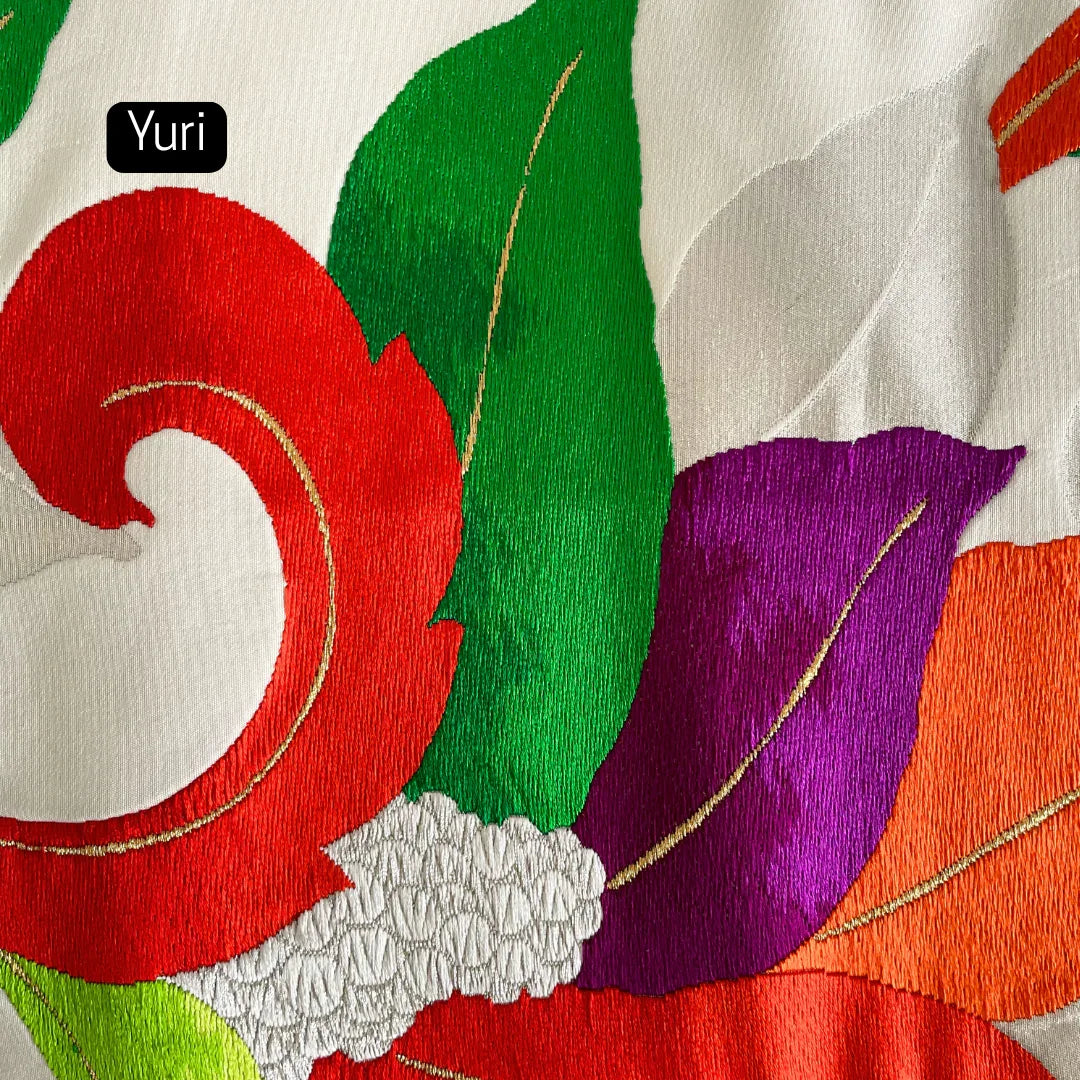 Close-up of vintage Obi kimono fabric with colorful floral embroidery in red, purple, green, and orange.