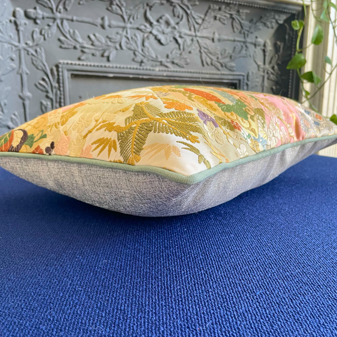 Vintage Japanese Obi-Kimono cushion with floral embroidery on a blue fabric surface