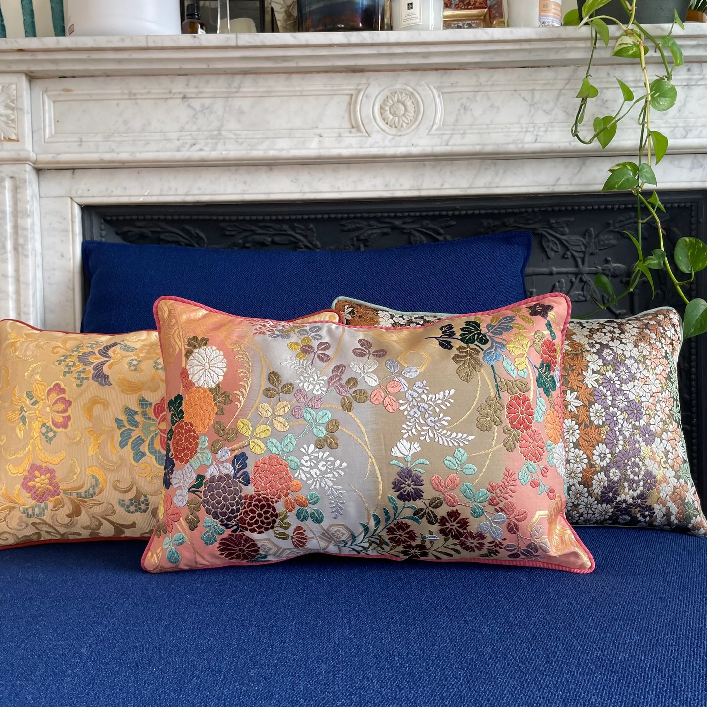 Vintage Obi Kimono silk cushions with colorful floral patterns on a blue sofa