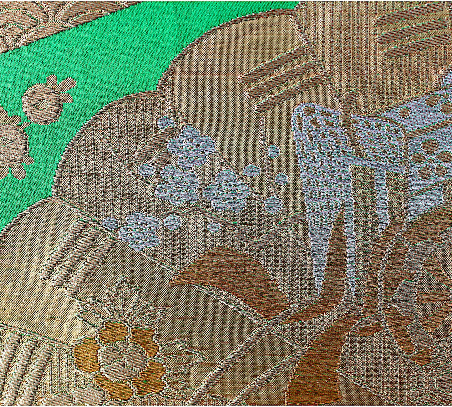 Close-up of vintage Japanese obi fabric with gold floral pattern on green background