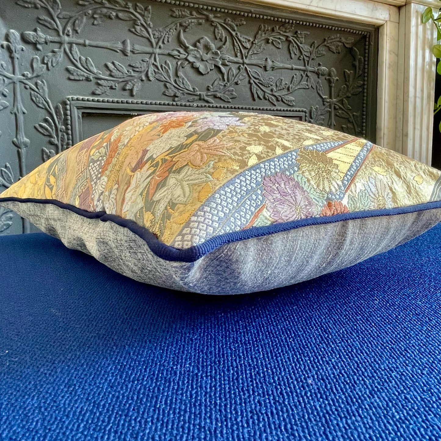 Vintage Japanese obi kimono cushion with floral pattern on blue fabric background