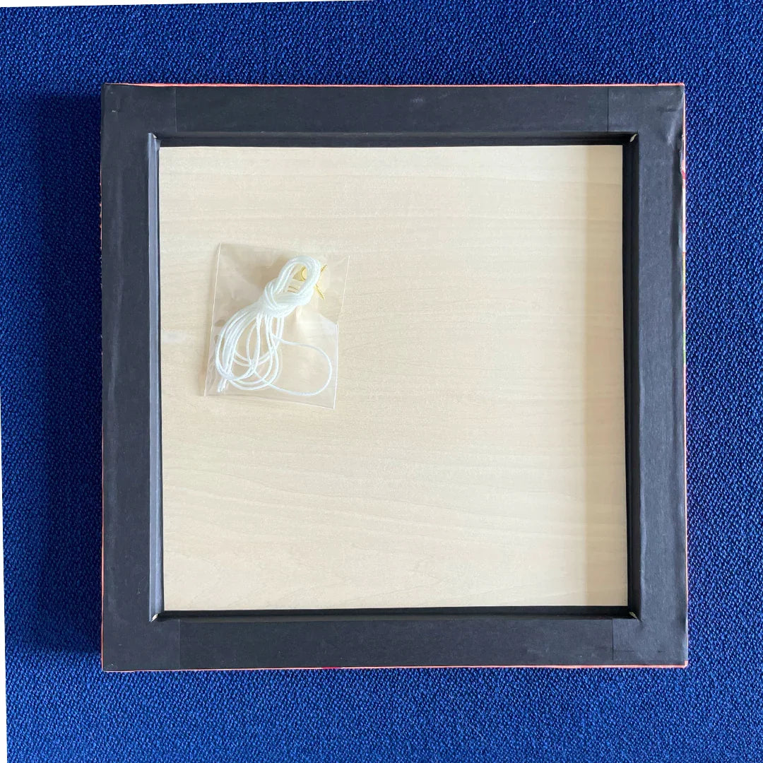 Back of framed artwork with hanging kit and blue textured background