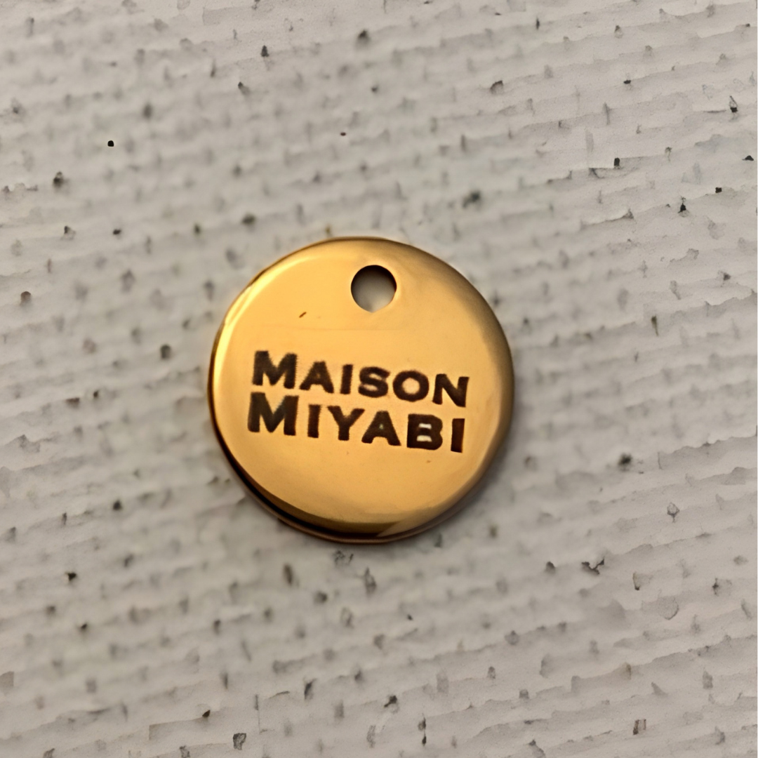 Médaille logo ronde en métal doré par MAISON MIYABI Paris